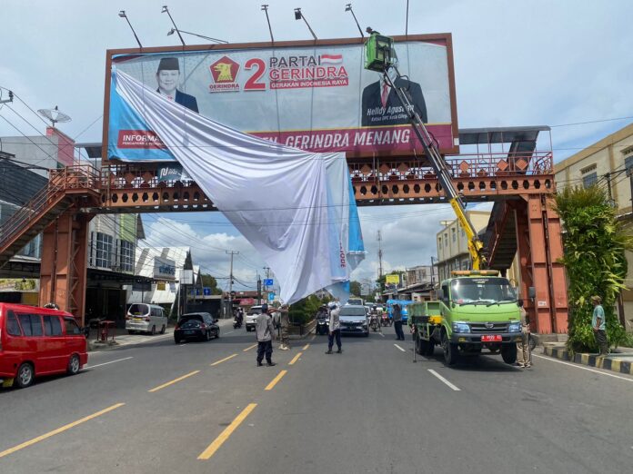 Bawaslu Kota Cilegon mencopot alat peraga kampanye calon kepala daerah saat di Jalan Ahmad Yani, Kota Cilegon, Senin (25/11/2024). Foto Elfrida Ully/Selatsunda.com